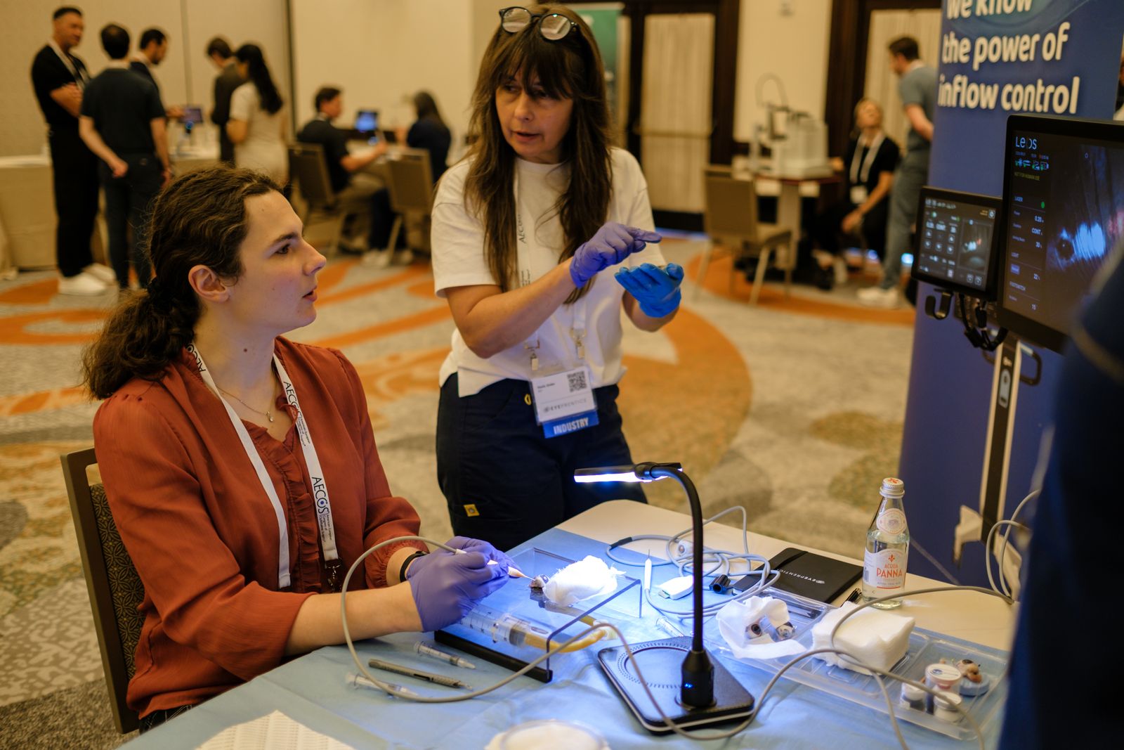 An industry partner coaching a resident at a hands-on training station