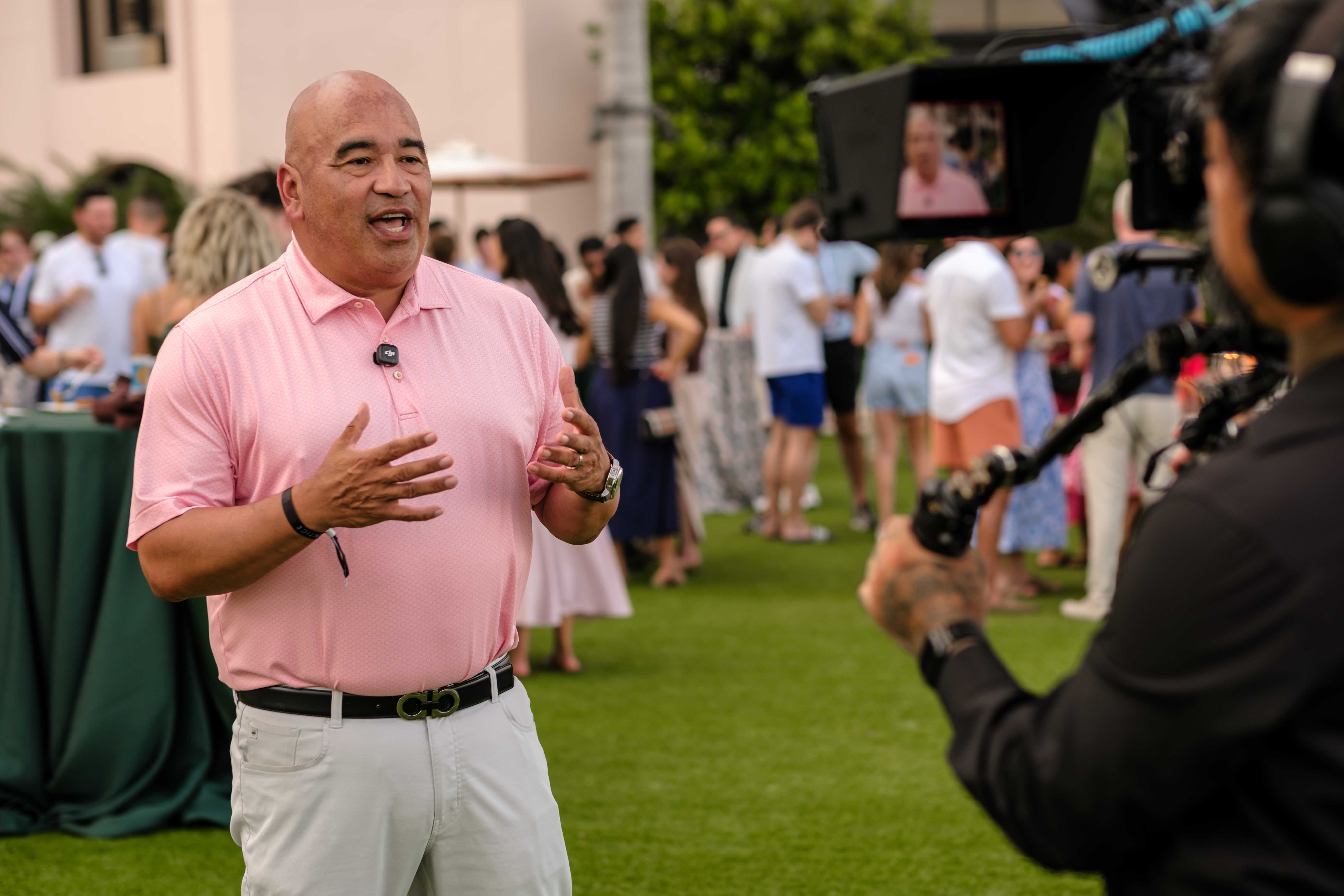 An attendee being interviewed on camera at an outdoor reception
